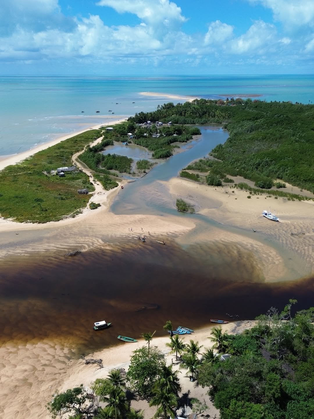 Vista aérea da foz do rio e da vila de Corumbau com barcos na areia