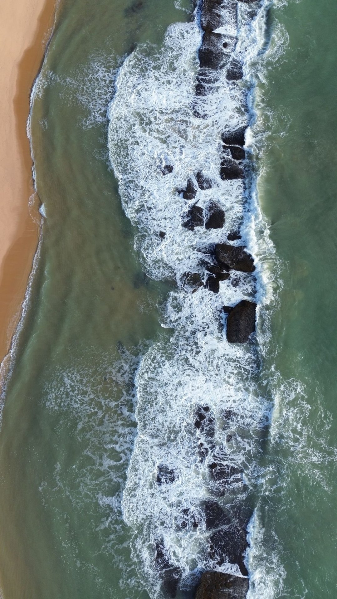 Vista aérea da faixa de recifes da Pedra do Nego acompanhando a praia