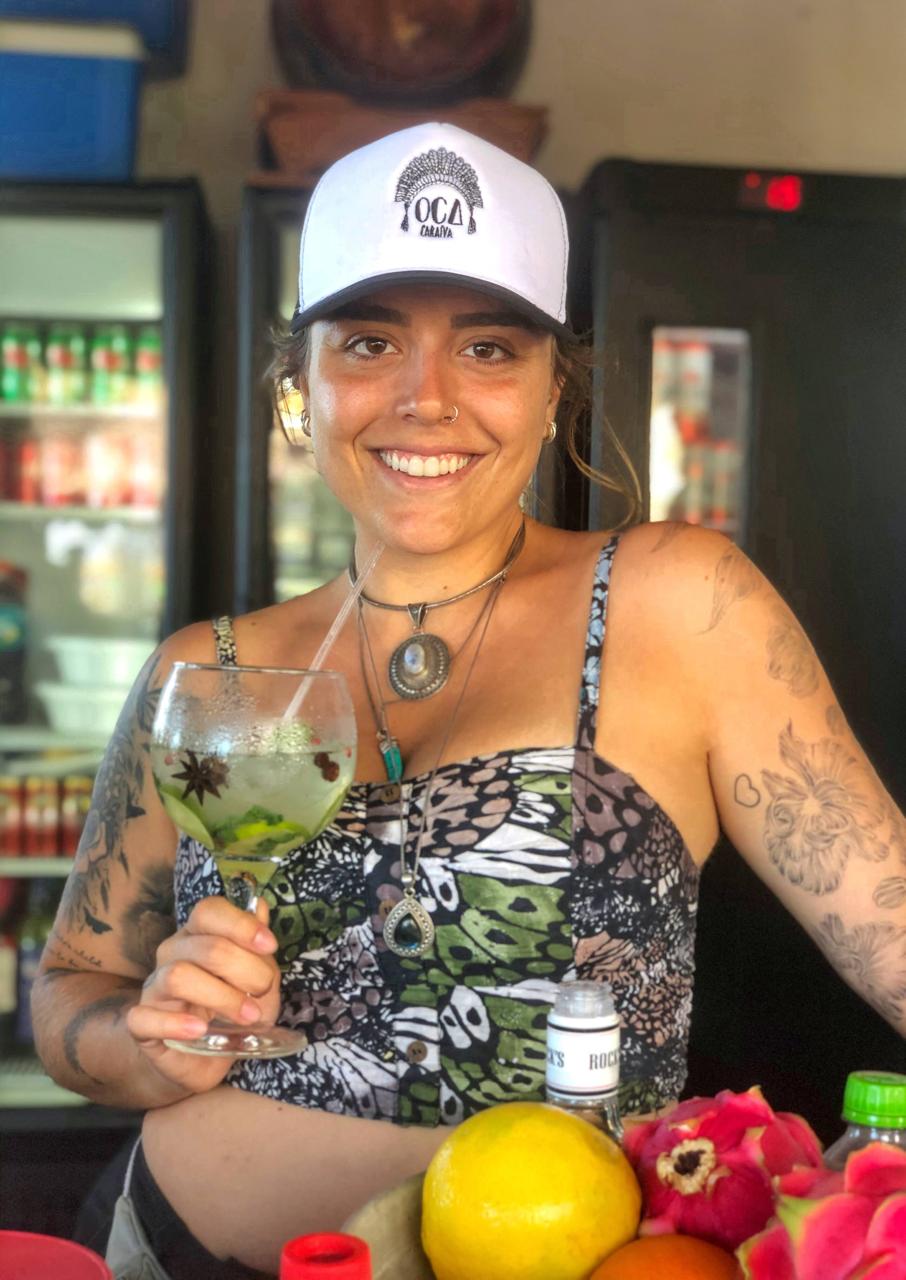 Michelle sorrindo com o boné da OCA Caraíva