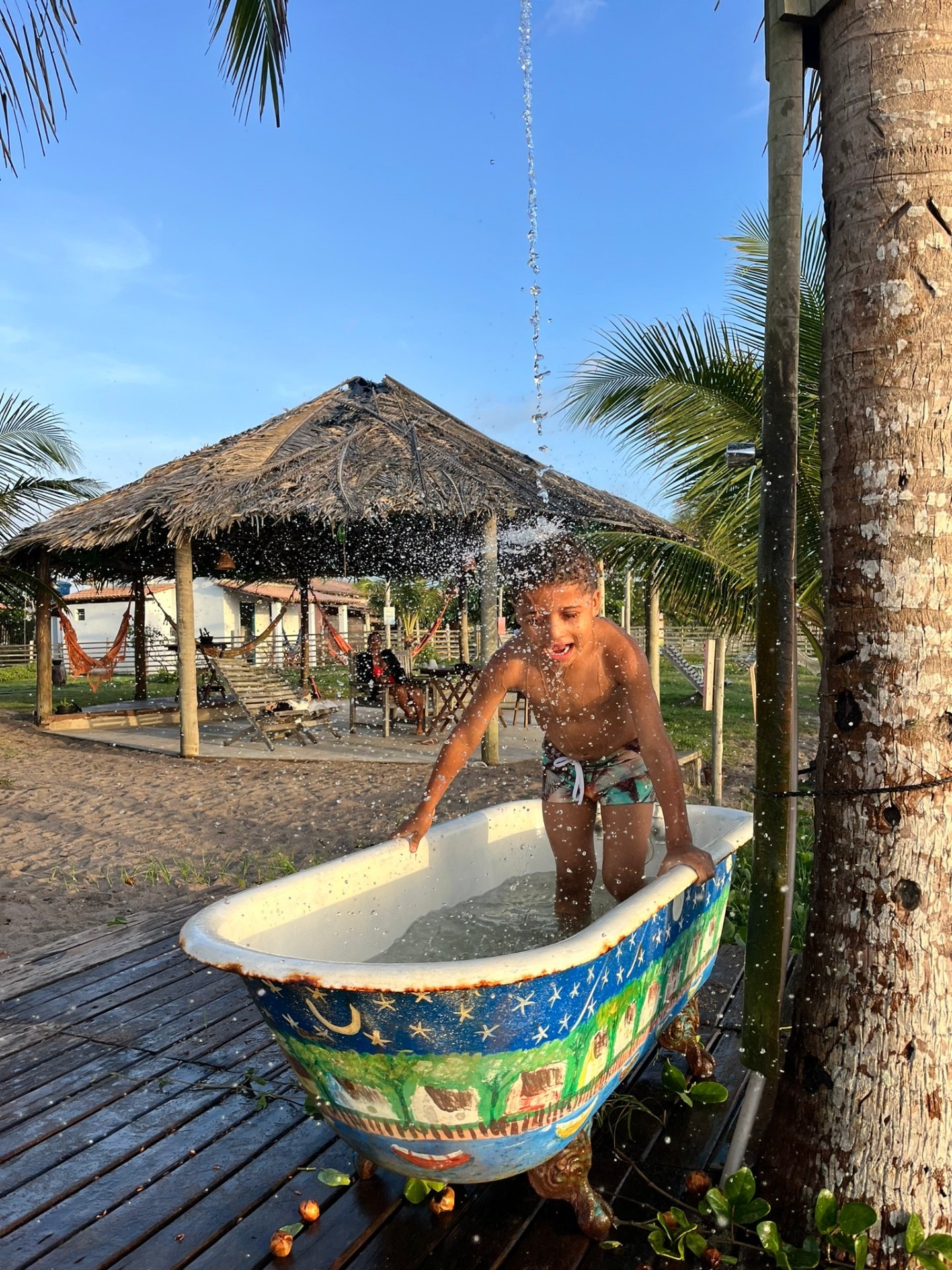 Criança se refrescando na banheira pintada à mão